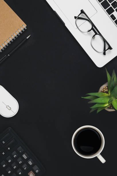 istock Flat lay black background with laptop, coffee cup and calculator, top view. 1492558875