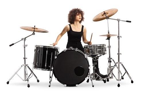 Female drummer performing isolated on white background