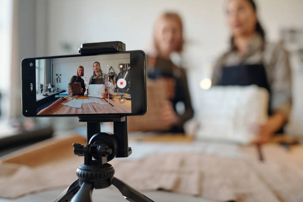 istock Two creative craftswomen on screen of smartphone standing on tripod 1492560710
