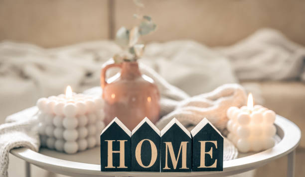istock Cozy composition with decorative word home, candles and vase on blurred background. 1492561525