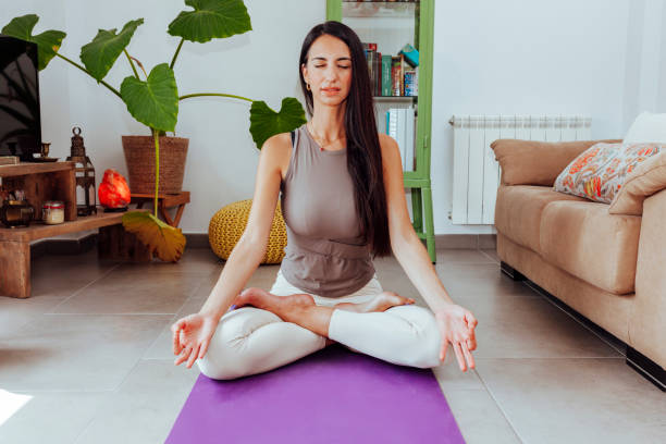 istock Young woman doing yoga exercise at home 1492562376