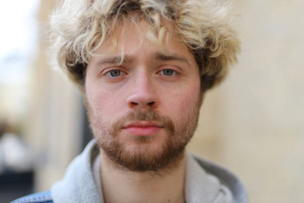 istock Serious portrait of a curly-haired man, outside. 1492564374