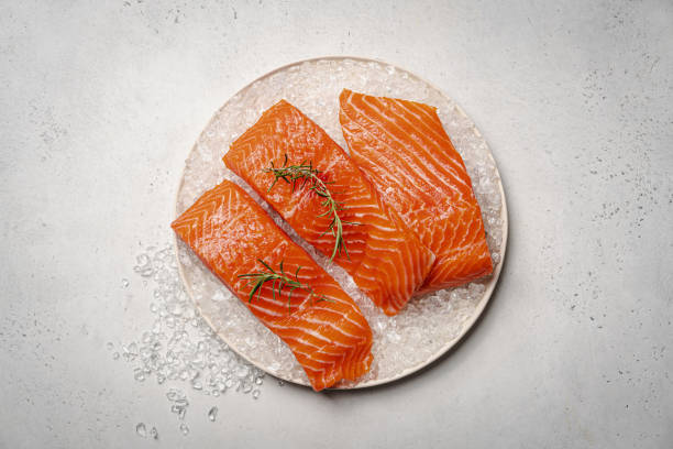 Fresh raw salmon fish fillet Salmon. Fresh raw salmon fish fillet with ice and herbs on white background, top view salmon stock pictures, royalty-free photos & images