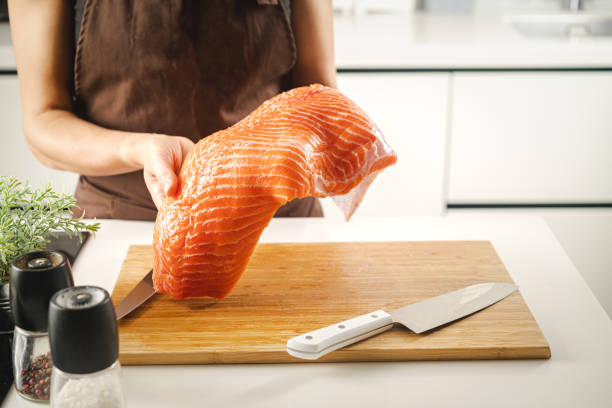 istock Women hold a raw salmon fillet 1492567669