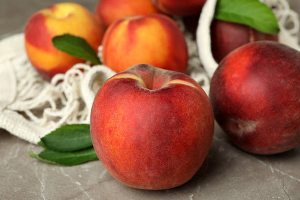 istock String bag with peach fruits on gray textured table 1492567758