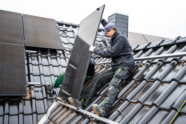 Team of technicians installing solar panels on the roof of a house stock photo