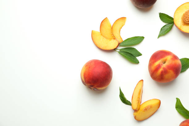 istock Ripe peach fruits with leaves on white background 1492568548