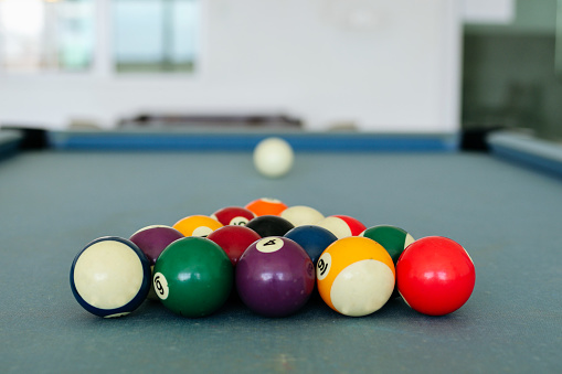 There are colorful billiard balls on the pool table, ready to start the game.