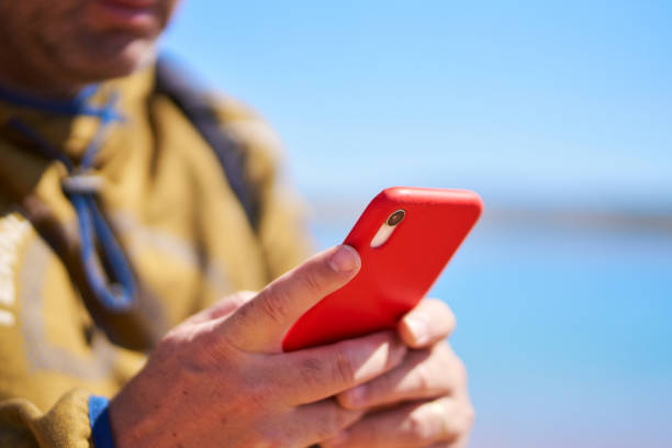 istock an unrecognizable man looking at his cell phone on a lake shore 1492572456