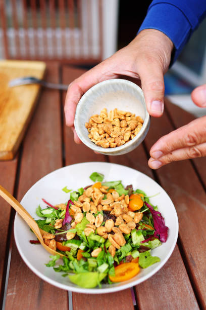 istock Close up of chef adds nuts to salat 1492579905
