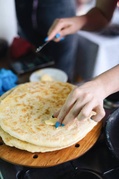 istock Young Woman Buttering Freshly Cooked Khachapuri 1492580111