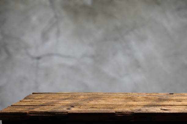istock Empty wooden board on table top and blur inside over stucco wall blur background, mock up for display of goods. 1492582300
