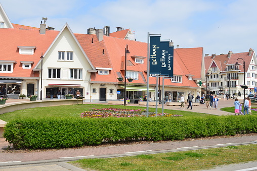 De Haan aan Zee, West-Flanders, Belgium - May 21, 2023: small business shops townhouses, orange roof tiles on a town square