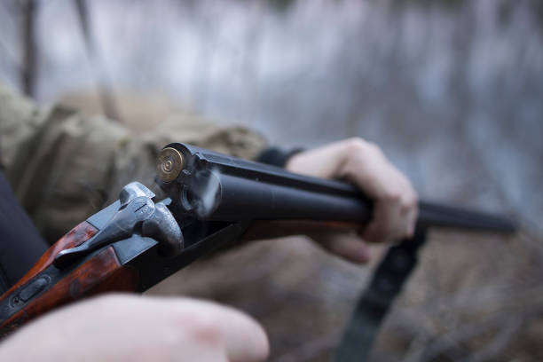 istock Hunter man hunts with a gun for ducks on the river bank 1492584185