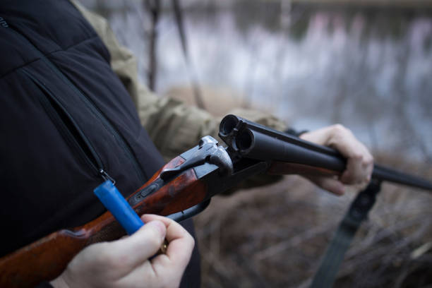 istock Hunter man hunts with a gun for ducks on the river bank 1492584246