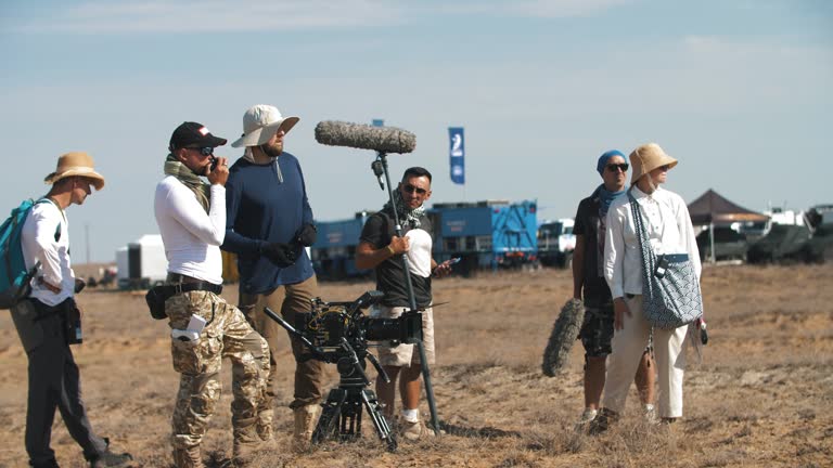 Film crew in the desert. trucks rush along the steppe road. extreme conditions of movie production.