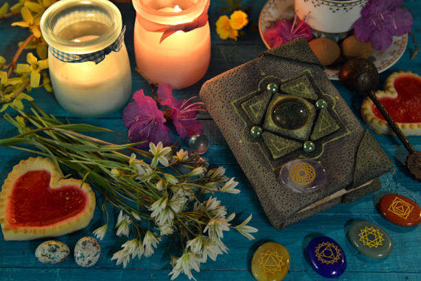 istock Book of spells, candles and chakras on witch ritual table. Occult, esoteric and divination still life. Mystic background with vintage objects 1492589735