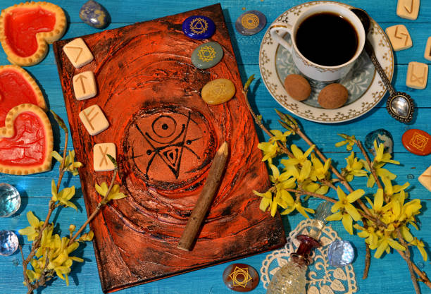 istock Old magic book with spells, runes, crystals and cup on witch altar table. Occult, esoteric and divination still life. 1492589857