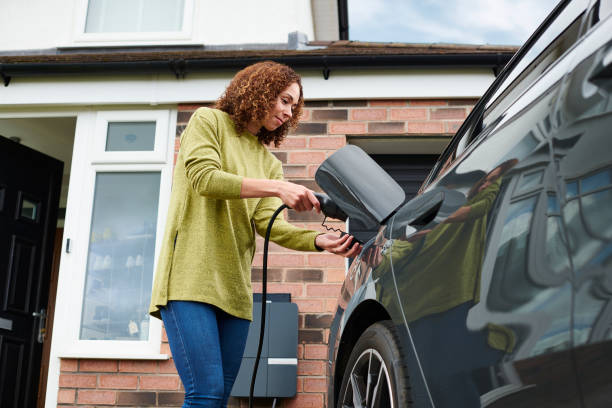istock homeowner charging electric car on driveway 1492590985