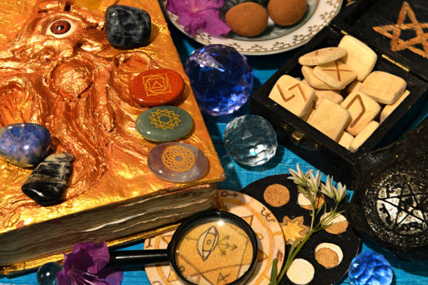 istock Chakras, runes and magic book of spell on witch altar table. Occult, esoteric and divination still life. Mystic background with vintage objects 1492592153