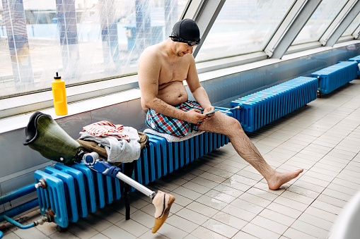 Man sits on a radiator and uses a mobile phone