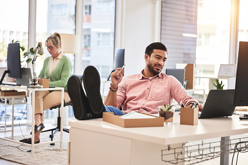 Relax business man with his feet up on desk working on laptop for job confidence and successful career. Asian CEO, boss or professional person relaxing in office on computer