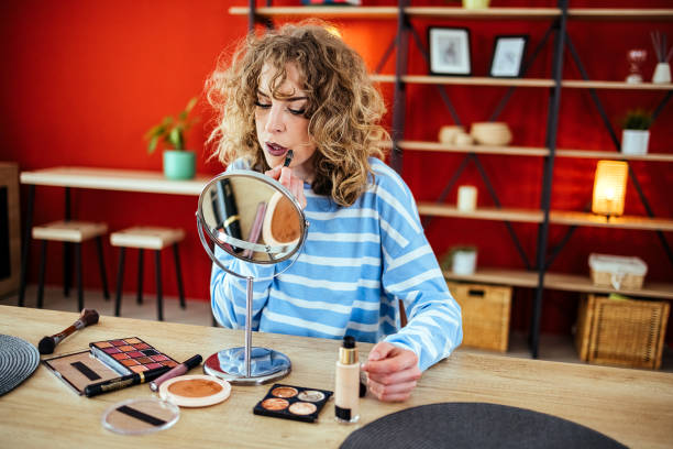 istock Beautiful young woman applying lip gloss. 1492594292