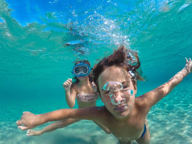 istock Boy looking at camera and having fun diving underwater 1492597296