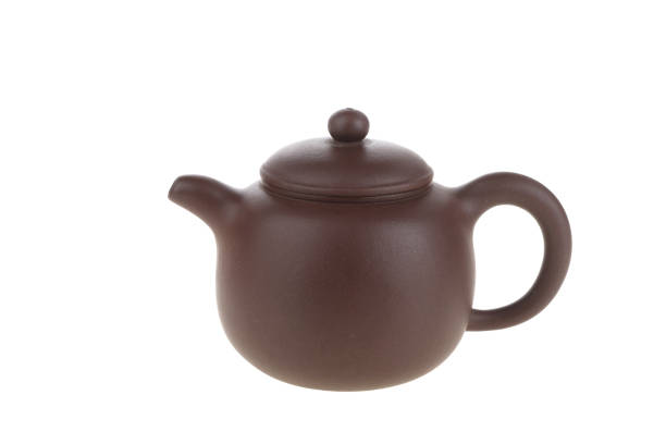 istock Dark-red enameled pottery teapot on white background 1492597504