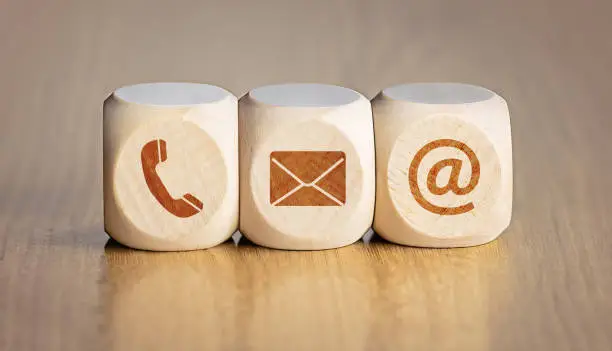 Contact us concept. Wooden blocks with email, mail and telephone icons.