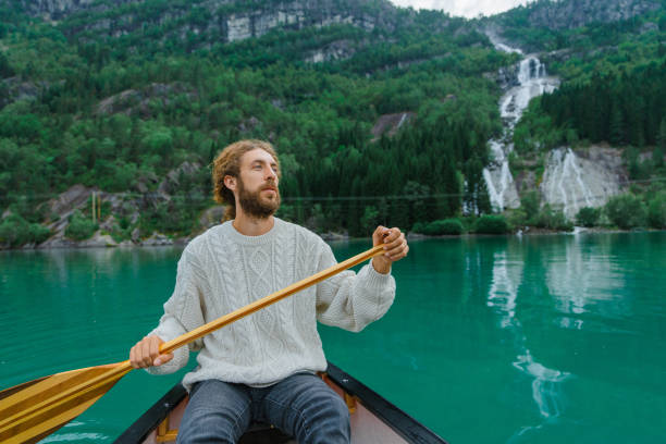 istock Man canoeing on the background of the waterfall 1492599710
