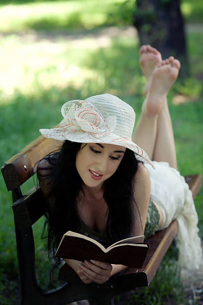 istock attractive girl sitting on the bench and reading book 149260051