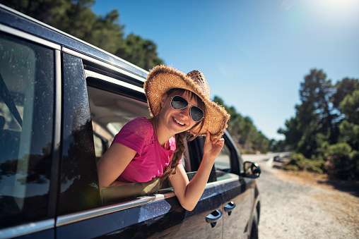 Girl aged 11 is looking out of the car window.  Sunny summer day in Andalusia, Spain.
Nikon D810