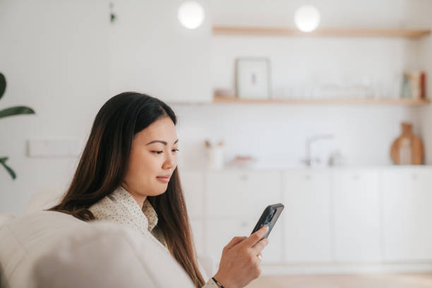 istock Woman using smart phone at home 1492609837