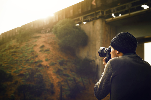 Nature, man and photographer with camera taking photo of a train on a bridge on vacation for break and adventure. Male, person and guy on a holiday with getaway photography and picture