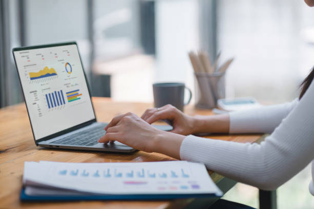 istock Businesswoman accountant using a graphs and charts to analyze market data, balance sheets,accounts,and net profits in order to plan new sales strategies and increase production capacity. 1492609941