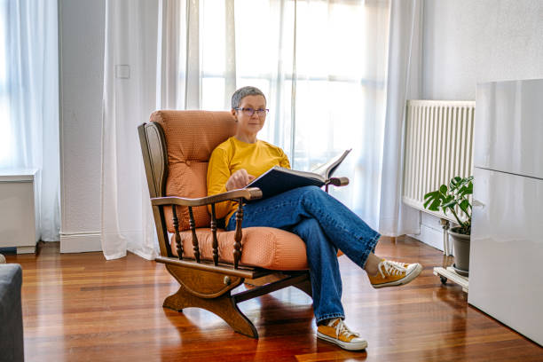 istock Mature woman reading a book on a chair 1492610486