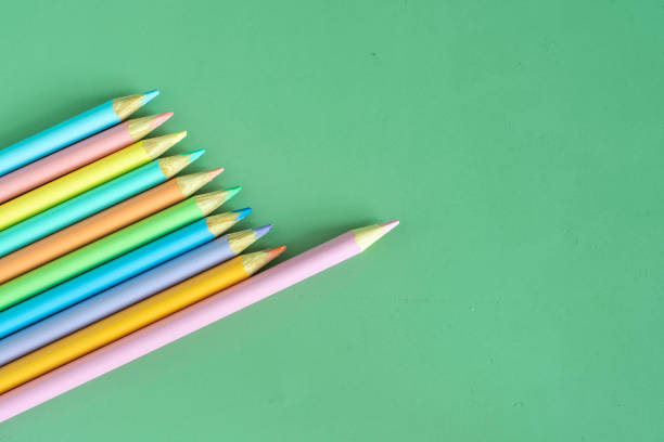 istock Pastel colored pencils, top view on green background, illustration concept, education and back to school 1492611103