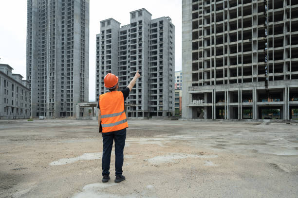 una ingeniera trabaja en un sitio de construcción usando una tableta - blueprint construction worker real estate new fotografías e imágenes de stock