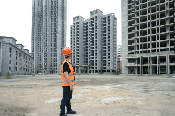 una ingeniera trabaja en un sitio de construcción usando una tableta - blueprint construction worker real estate new fotografías e imágenes de stock