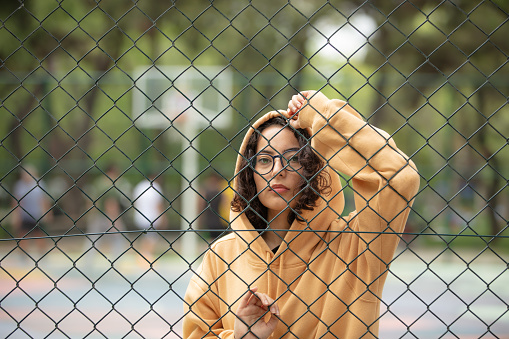 Young woman portrait with eyeglasses and yellow hoodie.