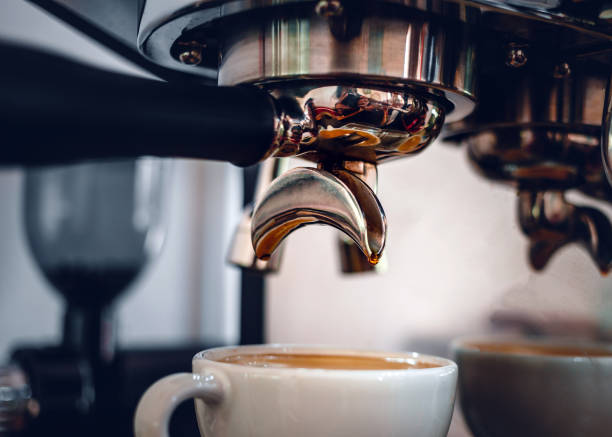 istock Espresso coffee extraction from a professional coffee machine with a bottomless filter, Close-up of a coffee drop  from the coffee machine 1492619311