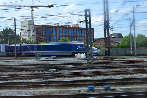 Brussels, Belgium  - May 20, 5, 2023: photographed from inside a moving passengers train on another riding intercontinental Eurostar speed train entering the Brussels-South railway station