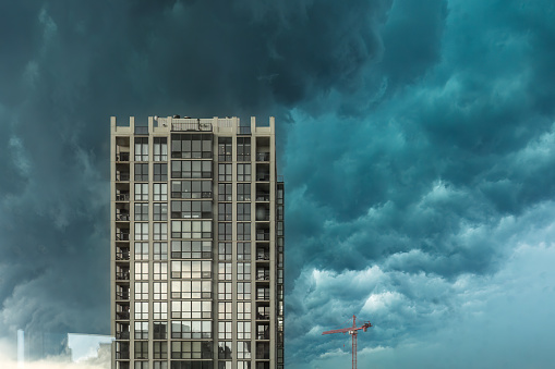 Dramatic overcast sky behind tall apartment building with intense clouds