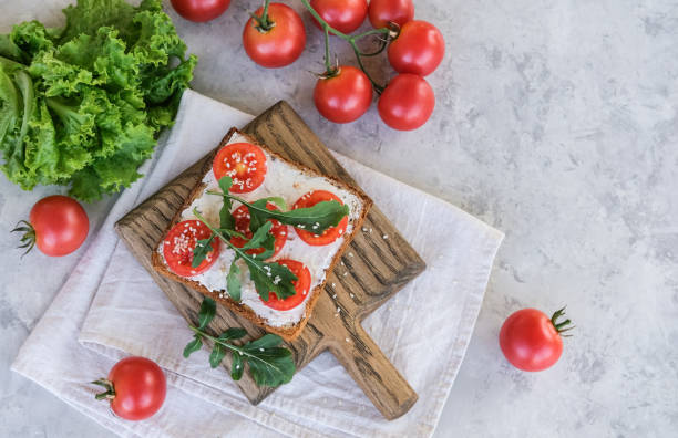istock Sandwich with cheese, tomatoes and arugula. Top view. Copy space 1492620675