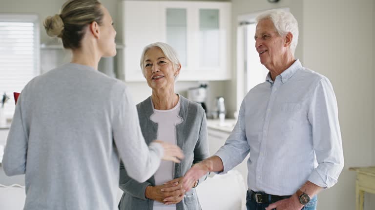 Handshake, talking and a senior couple with an advisor for retirement planning and home insurance. Meeting, greeting and an elderly man and woman shaking hands with a lawyer for legal support