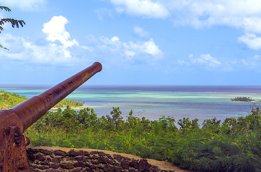 Bora Bora, French Polynesia - 2001: A photograph of an old World War II cannon perched on top of the extinct volcano of Mount Otemanu on the top of Bora Bora island overlooking the ocean below, as shot on the rare Canon EOS 1N - Kodak DCS 520, one of the first professional digital cameras.
