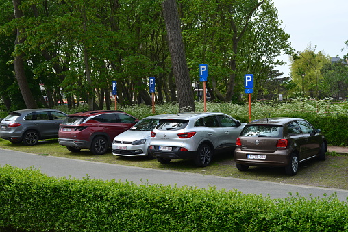 De Haan, West-Flanders, Belgium - May 21, 2023:  oddly enough, there are 4 road signs parking spaces for disabled drivers next to each other in a spot ion one luxury mansions area