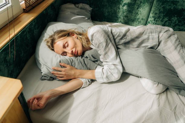 portrait d’une femme dormant sur un lit près de la fenêtre. jour utile sommeil relaxant. - woman sleeping photos et images de collection