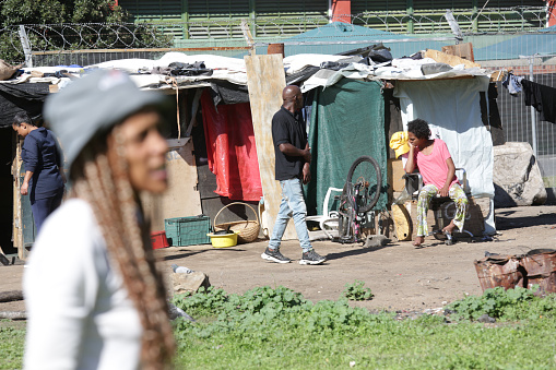 Cape Town, 09 May 2023. A stylish young woman with braided hair enjoys her music using earpods outside her shack home in the Bo-Kaap quarry, situated near the vibrant Cape Town CBD.